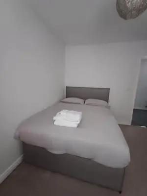 a bed with white sheets and towels on it at Great Home in Liverpool