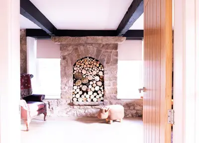 a living room with a stone fireplace with a chair at Luxury modern canal side cottage for families, couples, contractors and dog friendly in Lancashire sleeps 6 in Preston