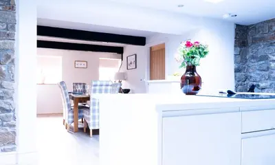 a kitchen with a counter with a vase of flowers on it at Luxury modern canal side cottage for families, couples, contractors and dog friendly in Lancashire sleeps 6 in Preston