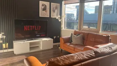 a living room with a couch and a flat screen tv at Balcony 60 Inch TV Penthouse City Centre with views in Liverpool