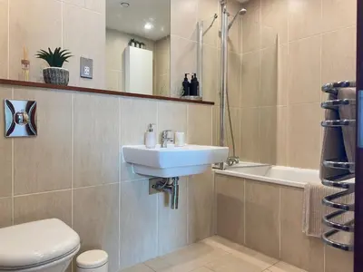 a bathroom with a sink and a toilet and a tub at Balcony 60 Inch TV Penthouse City Centre with views in Liverpool