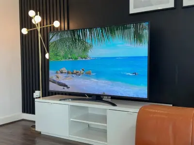 a flat screen tv sitting on top of a white entertainment center at Balcony 60 Inch TV Penthouse City Centre with views in Liverpool