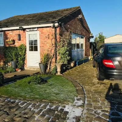 a brick house with a car parked in front of it at Sefton Cottage in Ormskirk