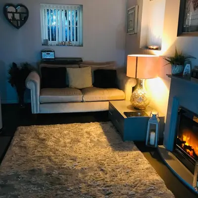 a living room with a couch and a fireplace at Sefton Cottage in Ormskirk