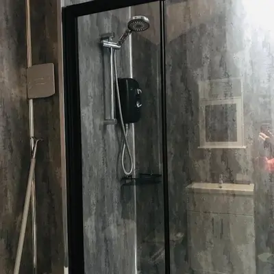 a shower with a shower head in a bathroom at Sefton Cottage in Ormskirk