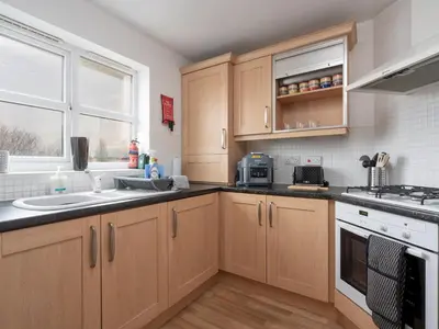 a kitchen with wooden cabinets and a sink at The Point, 2 Bed Flat, Parking - Pass the Keys in Liverpool