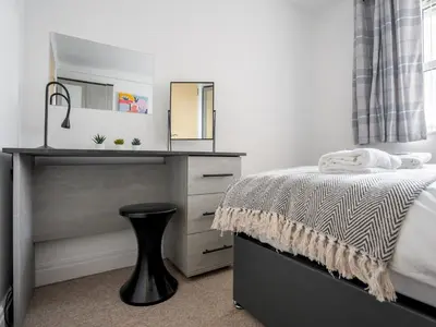 a bedroom with a bed and a dresser with a mirror at The Point, 2 Bed Flat, Parking - Pass the Keys in Liverpool