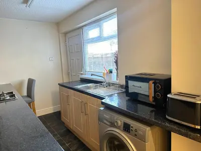 a kitchen with a washing machine and a window at Delightful Blackpool Home in Blackpool