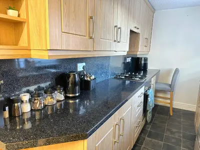 a kitchen with wooden cabinets and a black counter top at Delightful Blackpool Home in Blackpool