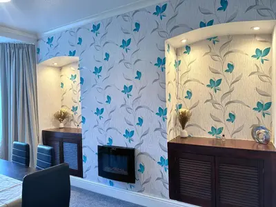 a living room with a fireplace and blue flowers on the wall at Delightful Blackpool Home in Blackpool