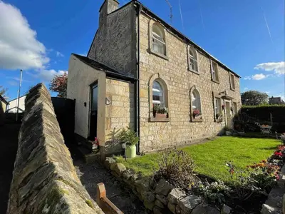 an old stone house with a stone wall at Cottage Apartment Near Lancaster University in Galgate