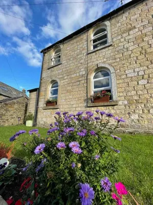 a brick building with flowers in front of it at Cottage Apartment Near Lancaster University in Galgate