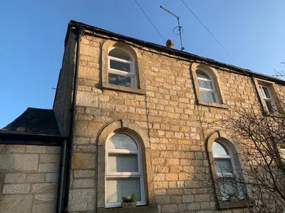 an old brick building with four windows on it at Cottage Apartment Near Lancaster University in Galgate