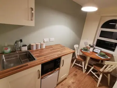a kitchen with a sink and a wooden counter top at Cottage Apartment Near Lancaster University in Galgate
