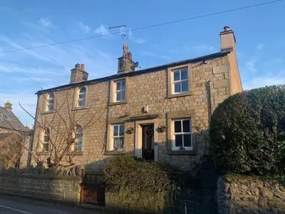 an old stone house on the side of a street at Cottage Apartment Near Lancaster University in Galgate
