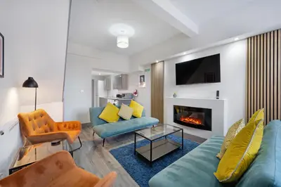 a living room with a couch and a fireplace at Burnand House - Air Host & Stay - Sleeps 9 in Liverpool