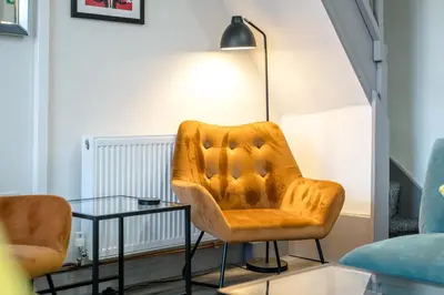 a living room with a chair and a glass table at Burnand House - Air Host & Stay - Sleeps 9 in Liverpool