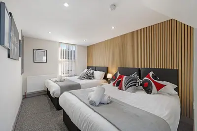 a hotel room with two beds with stuffed animals on them at Burnand House - Air Host & Stay - Sleeps 9 in Liverpool
