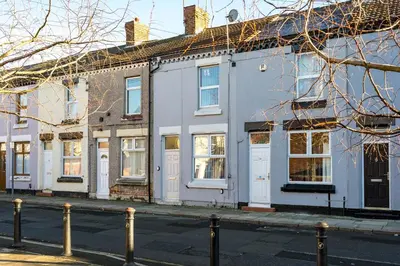 a row of white houses on a street at Burnand House - Air Host & Stay - Sleeps 9 in Liverpool