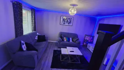 a purple living room with a couch and a table at Entire 3 bedroom luxurious house, Wigan , Manchester in Wigan