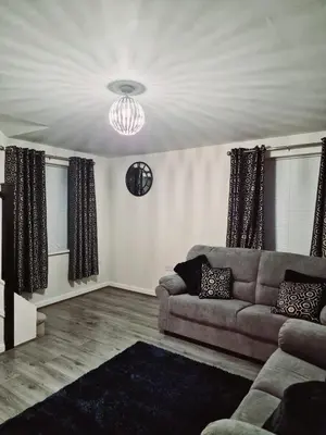 a living room with a couch and a chandelier at Entire 3 bedroom luxurious house, Wigan , Manchester in Wigan