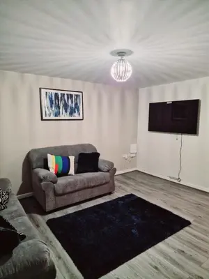 a living room with a couch and a flat screen tv at Entire 3 bedroom luxurious house, Wigan , Manchester in Wigan