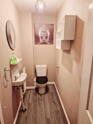 a small bathroom with a toilet and a sink at Entire 3 bedroom luxurious house, Wigan , Manchester in Wigan