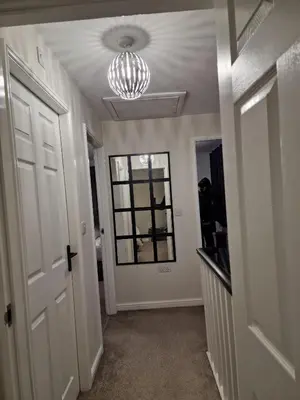 a hallway with a door and a chandelier at Entire 3 bedroom luxurious house, Wigan , Manchester in Wigan