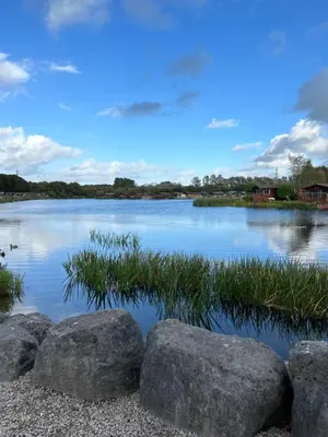 a view of a lake with rocks and grass at Stylish and cozy holiday home in Carnforth