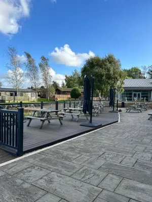 a group of picnic tables and umbrellas on a patio at Stylish and cozy holiday home in Carnforth