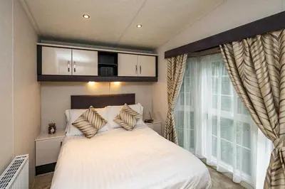 a bedroom with a large white bed and a window at Stylish and cozy holiday home in Carnforth