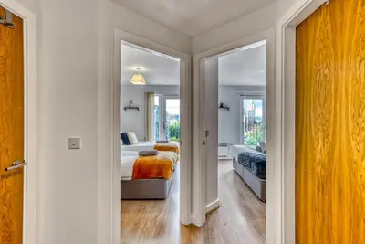 a bedroom with two beds and a mirror at Cosy Central 2-Bed Flat City View & Parking in Wigan