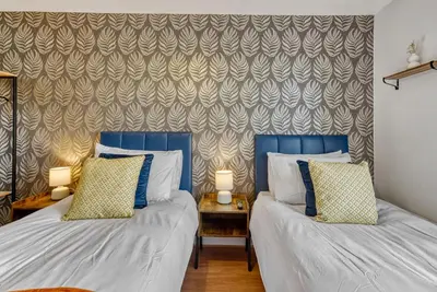 two beds sitting next to each other in a bedroom at Cosy Central 2-Bed Flat City View & Parking in Wigan