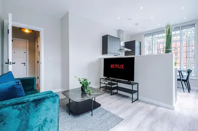 a living room with a tv and a table at Elysée Suites - Stylish 1 Bed Flat in Southport in Southport