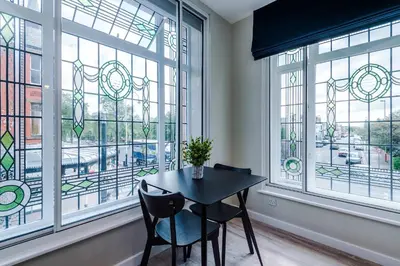 a table and two chairs in a room with windows at Elysée Suites - Stylish 1 Bed Flat in Southport in Southport