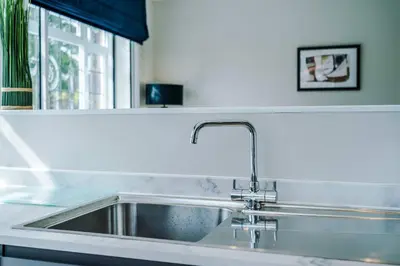 a stainless steel sink in a kitchen with a window at Elysée Suites - Stylish 1 Bed Flat in Southport in Southport