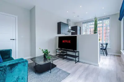 a living room with a tv and a table at Elysée Suites - Stylish 1 Bed Flat in Southport in Southport