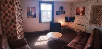 a living room with a couch and a table at Oakville Apartments in Blackpool