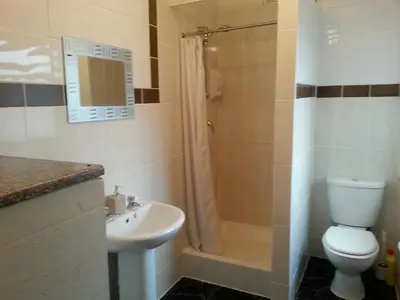 a bathroom with a toilet and a shower and a sink at Oakville Apartments in Blackpool