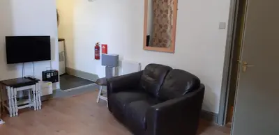 a black leather chair in a living room with a television at Oakville Apartments in Blackpool
