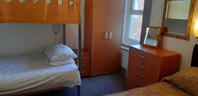 a bedroom with two bunk beds and a mirror at Oakville Apartments in Blackpool