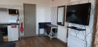 a living room with a flat screen tv on a wall at Oakville Apartments in Blackpool