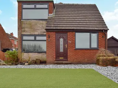 a red brick house with a brown door at West Park House in Penwortham