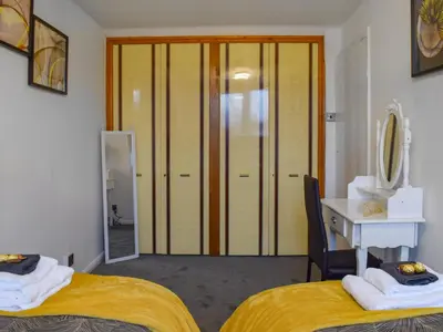 a room with two beds and a desk and a mirror at West Park House in Penwortham