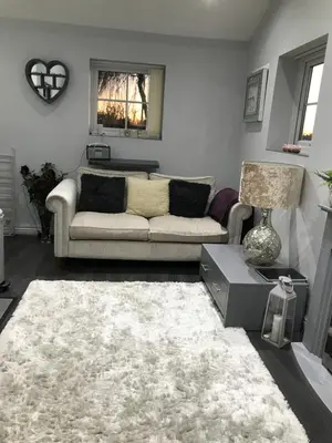 a living room with a couch and a rug at Sefton Cottage in Ormskirk