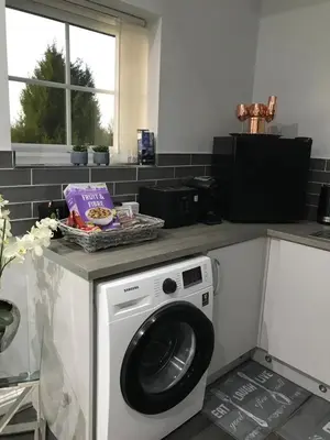 a kitchen with a washing machine on a counter at Sefton Cottage in Ormskirk