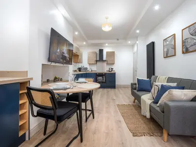 a living room and kitchen with a table and a couch at Bohemian Apartment, free WiFi and parking in New Brighton