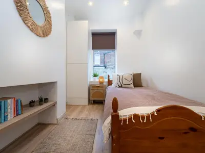 a bedroom with a large bed and a window at Bohemian Apartment, free WiFi and parking in New Brighton