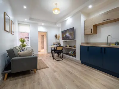 a kitchen and living room with a couch and a table at Bohemian Apartment, free WiFi and parking in New Brighton