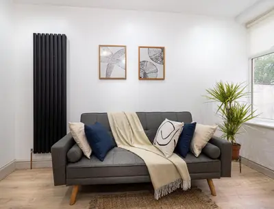 a living room with a gray couch with pillows at Bohemian Apartment, free WiFi and parking in New Brighton